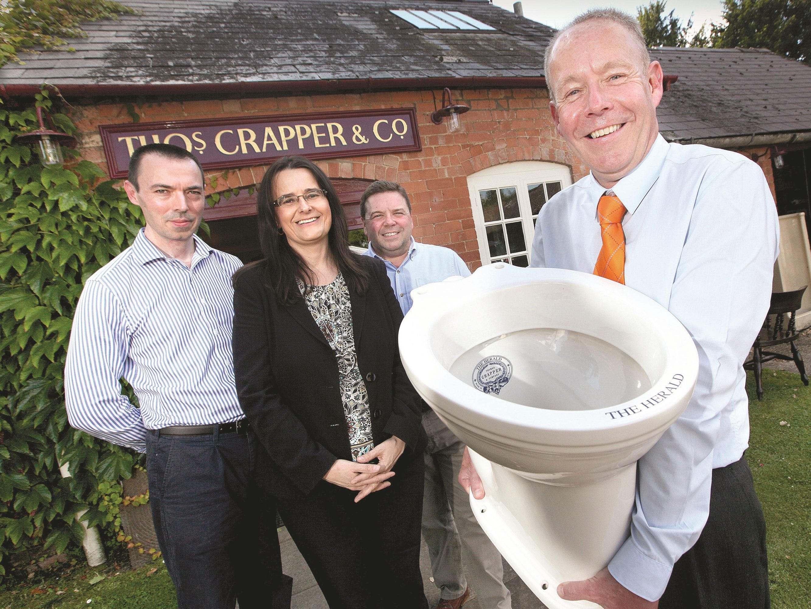 Herald staff with the new toilet pan from Thomas Crapper